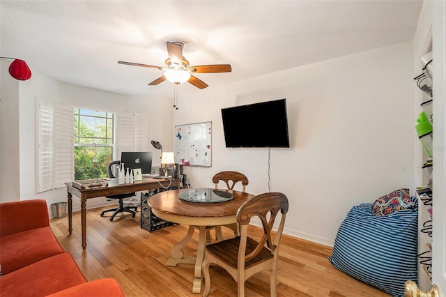 office with light wood-type flooring and ceiling fan