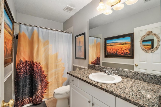 bathroom featuring a textured ceiling, toilet, vanity, and tile patterned flooring