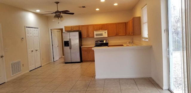 kitchen featuring ceiling fan, light tile patterned floors, appliances with stainless steel finishes, and a healthy amount of sunlight