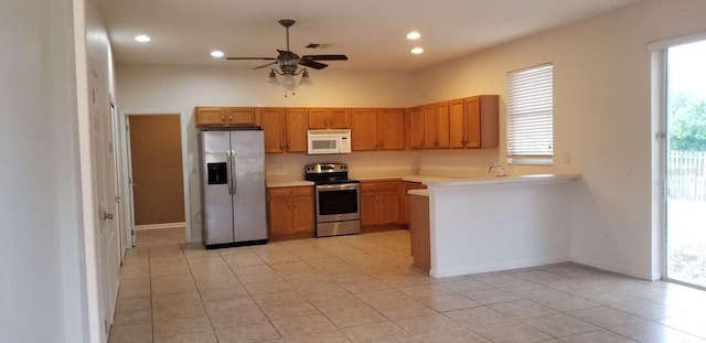 kitchen featuring light tile patterned floors, stainless steel appliances, and ceiling fan