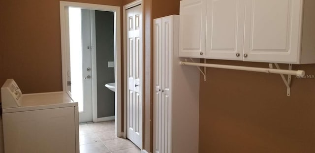 laundry area with cabinets, light tile patterned floors, and washer / dryer