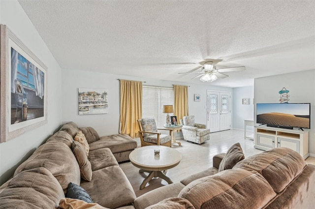 living room with ceiling fan and a textured ceiling