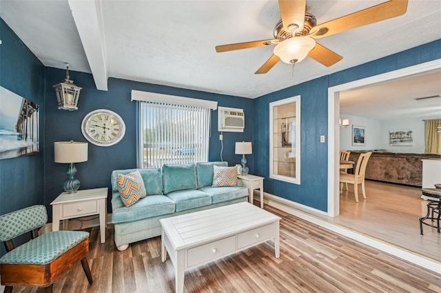 living room with beamed ceiling, ceiling fan, a wall mounted AC, and hardwood / wood-style floors