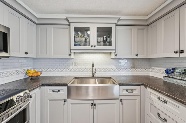 kitchen with sink, backsplash, stainless steel appliances, and white cabinets