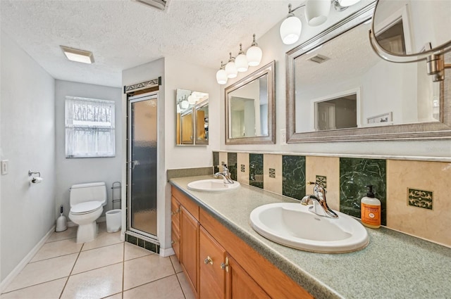 bathroom with tile patterned flooring, vanity, a textured ceiling, toilet, and walk in shower