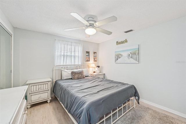 bedroom with hardwood / wood-style flooring, ceiling fan, and a closet