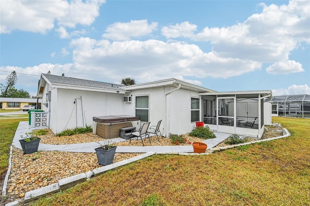 back of house with a hot tub, a sunroom, and a yard