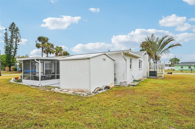 view of property exterior featuring a yard, a sunroom, and central air condition unit