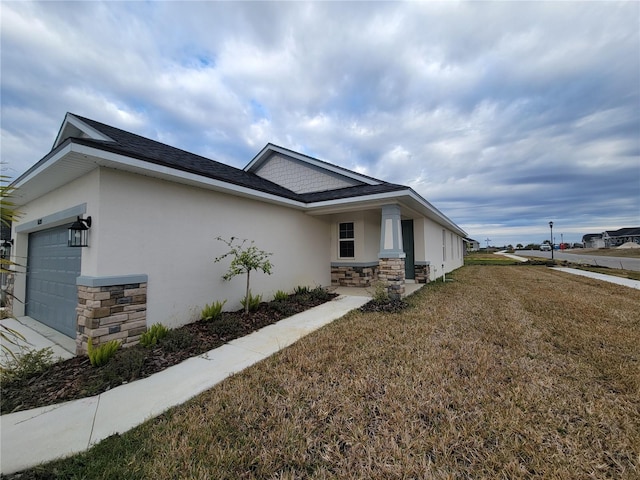 view of side of home featuring a garage and a yard