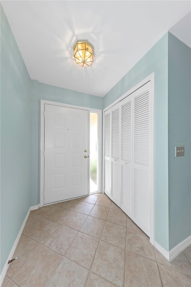 foyer entrance with baseboards and light tile patterned floors