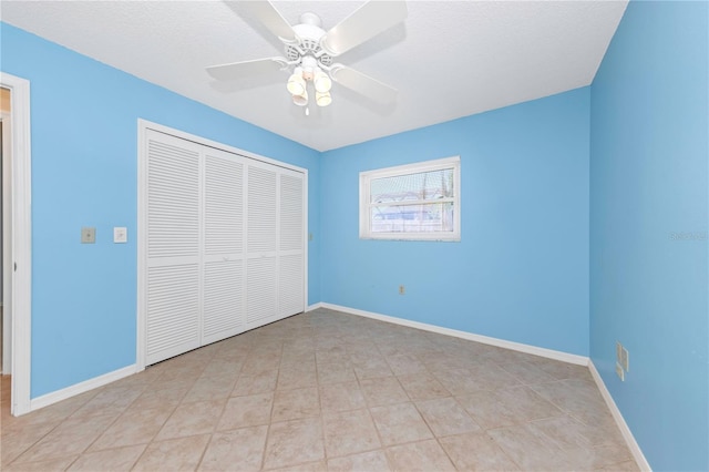 unfurnished bedroom featuring a textured ceiling, a closet, a ceiling fan, and baseboards