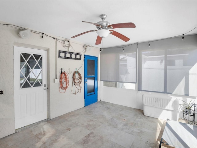 unfurnished sunroom with ceiling fan