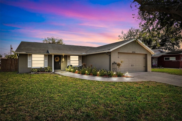 ranch-style home with a garage and a lawn