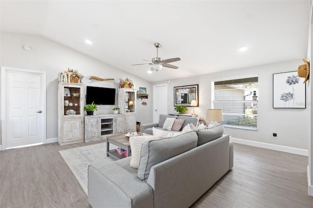 living room with hardwood / wood-style flooring, vaulted ceiling, and ceiling fan