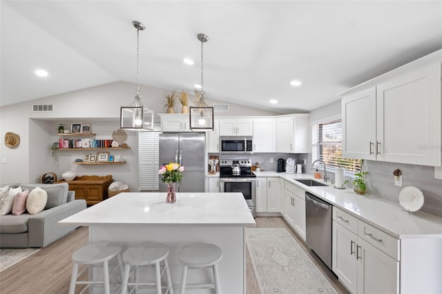 kitchen with pendant lighting, sink, decorative backsplash, and appliances with stainless steel finishes