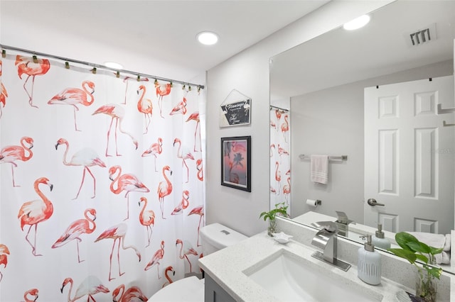 bathroom with walk in shower, vanity, and toilet