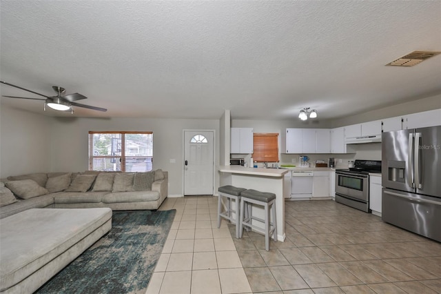 living room with ceiling fan, a textured ceiling, and light tile patterned floors