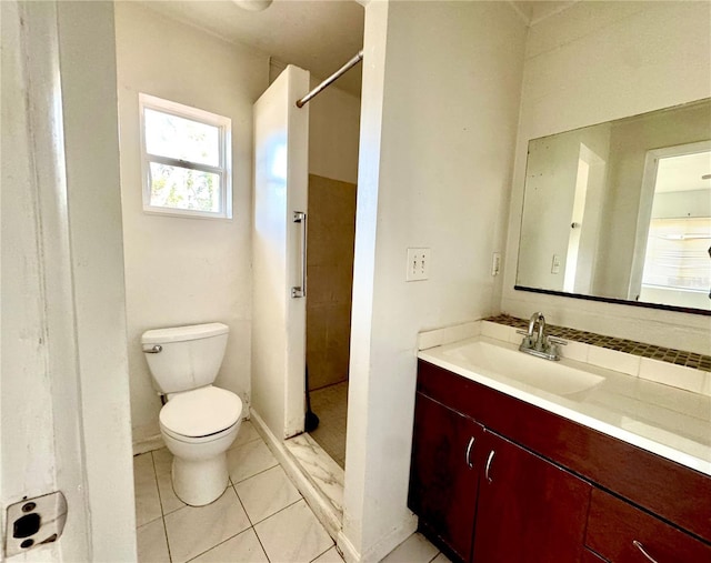 bathroom featuring vanity, tile patterned floors, toilet, and a shower