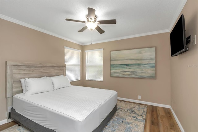 bedroom with ceiling fan, crown molding, and hardwood / wood-style flooring