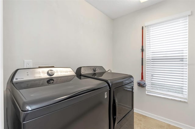 laundry area with separate washer and dryer, light tile patterned floors, and a healthy amount of sunlight