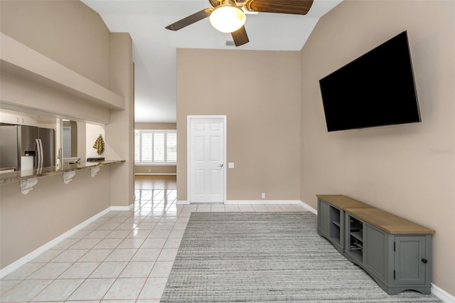 unfurnished living room featuring ceiling fan, tile patterned floors, and vaulted ceiling