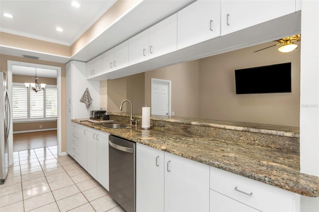 kitchen featuring white cabinets, dark stone counters, ceiling fan with notable chandelier, and ornamental molding