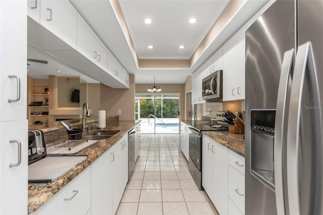 kitchen with decorative light fixtures, appliances with stainless steel finishes, sink, and white cabinetry