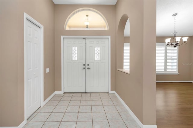 foyer entrance with light tile patterned floors and a chandelier