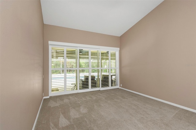 carpeted empty room with a healthy amount of sunlight and vaulted ceiling