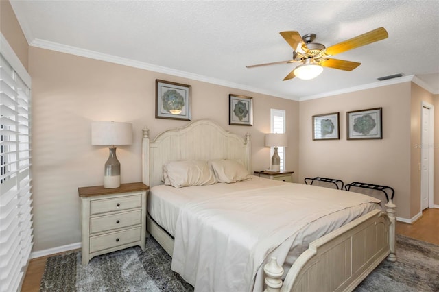 bedroom featuring ceiling fan, ornamental molding, and a textured ceiling