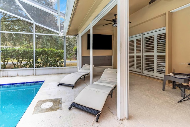 view of patio with ceiling fan and glass enclosure