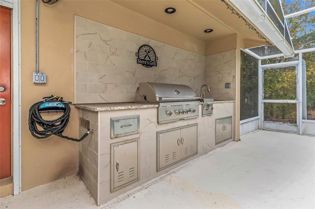 view of patio / terrace with exterior kitchen, grilling area, and glass enclosure