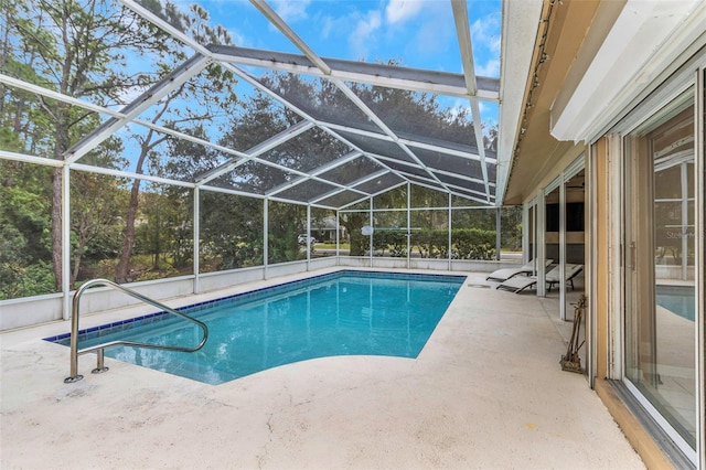 view of swimming pool featuring glass enclosure and a patio