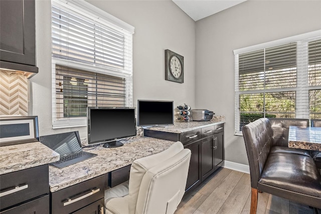 office space with built in desk and light hardwood / wood-style floors