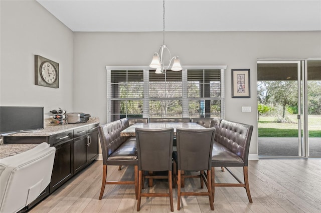 dining space with light hardwood / wood-style flooring and a notable chandelier