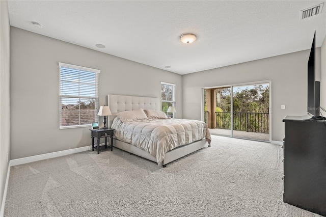 carpeted bedroom featuring multiple windows, access to outside, and a textured ceiling