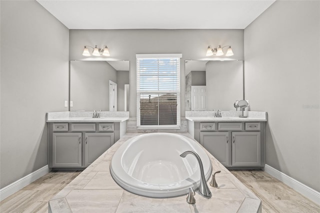 bathroom with vanity and tiled tub