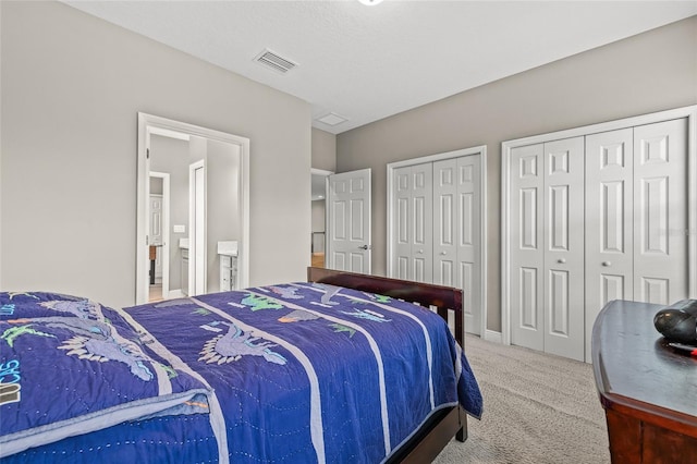 bedroom with carpet flooring and two closets