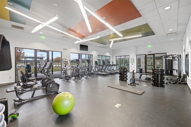 exercise room with a towering ceiling and a drop ceiling