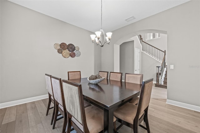 dining area featuring a notable chandelier and light hardwood / wood-style flooring