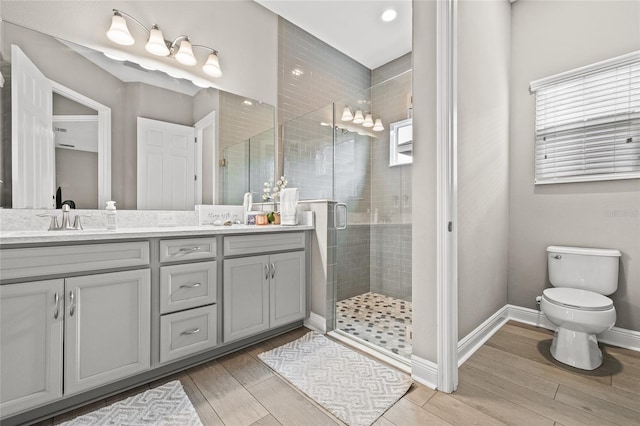 6307 Brevada Ln, Apollo Beach, FL 33572 - bathroom featuring double vanity, a stall shower, wood finished floors, toilet, and recessed lighting