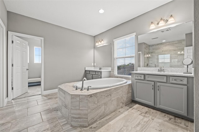 6307 Brevada Ln, Apollo Beach, FL 33572 - full bath featuring tiled shower, two vanities, a garden tub, plenty of natural light, and recessed lighting