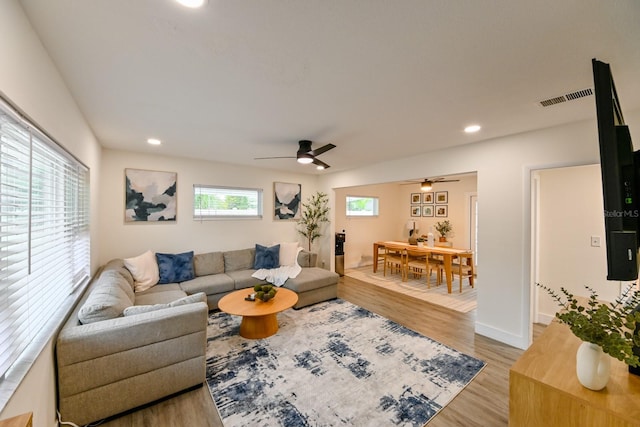 living area featuring recessed lighting, visible vents, light wood-style floors, and a ceiling fan