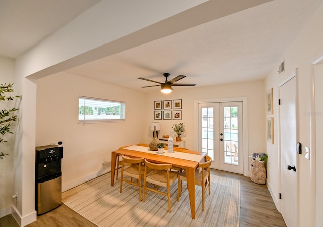 dining space featuring light wood finished floors, french doors, baseboards, and a ceiling fan