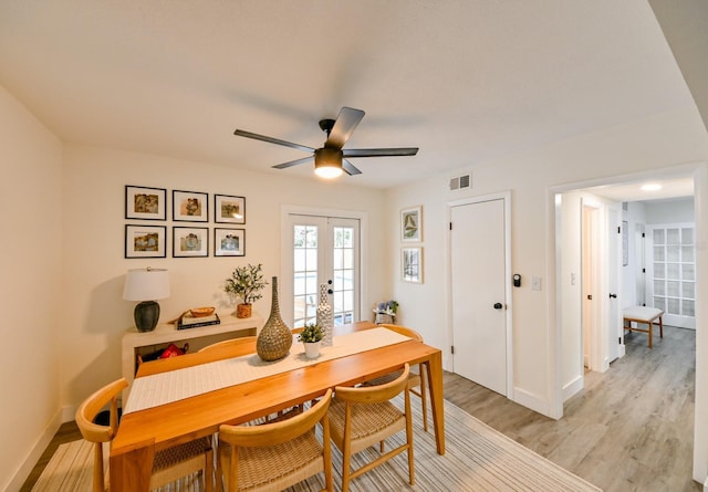 dining room featuring visible vents, baseboards, light wood-type flooring, french doors, and a ceiling fan