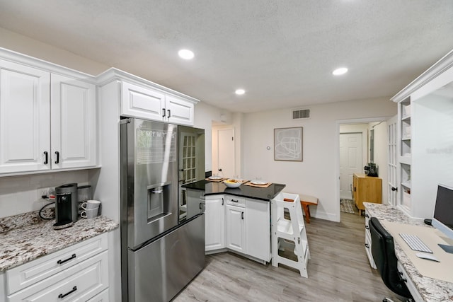 kitchen with visible vents, light wood-style flooring, recessed lighting, white cabinets, and stainless steel fridge with ice dispenser