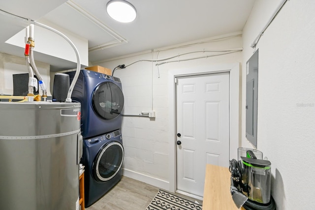 washroom featuring wood finished floors, secured water heater, laundry area, electric panel, and stacked washer and clothes dryer