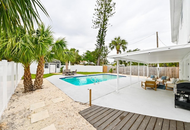 view of pool with a fenced in pool, an outbuilding, a fenced backyard, and a patio area