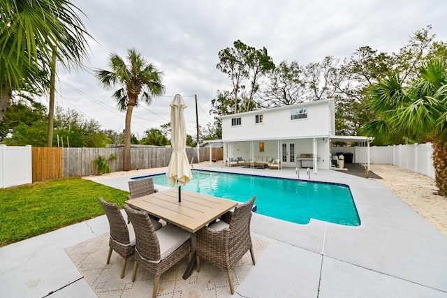 view of pool with french doors, outdoor dining area, a fenced backyard, and a patio