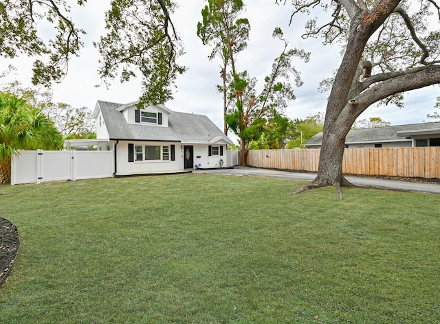 rear view of house featuring a shingled roof, a yard, a fenced backyard, a patio area, and a gate